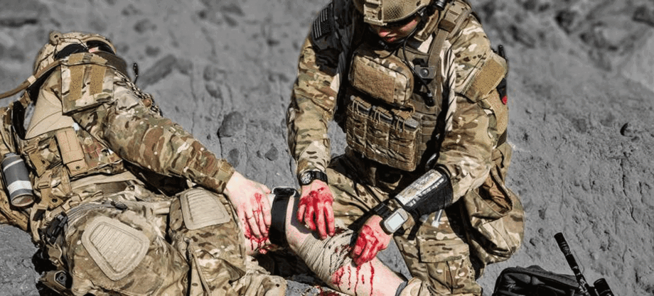 Soldiers administering first aid on battlefield.